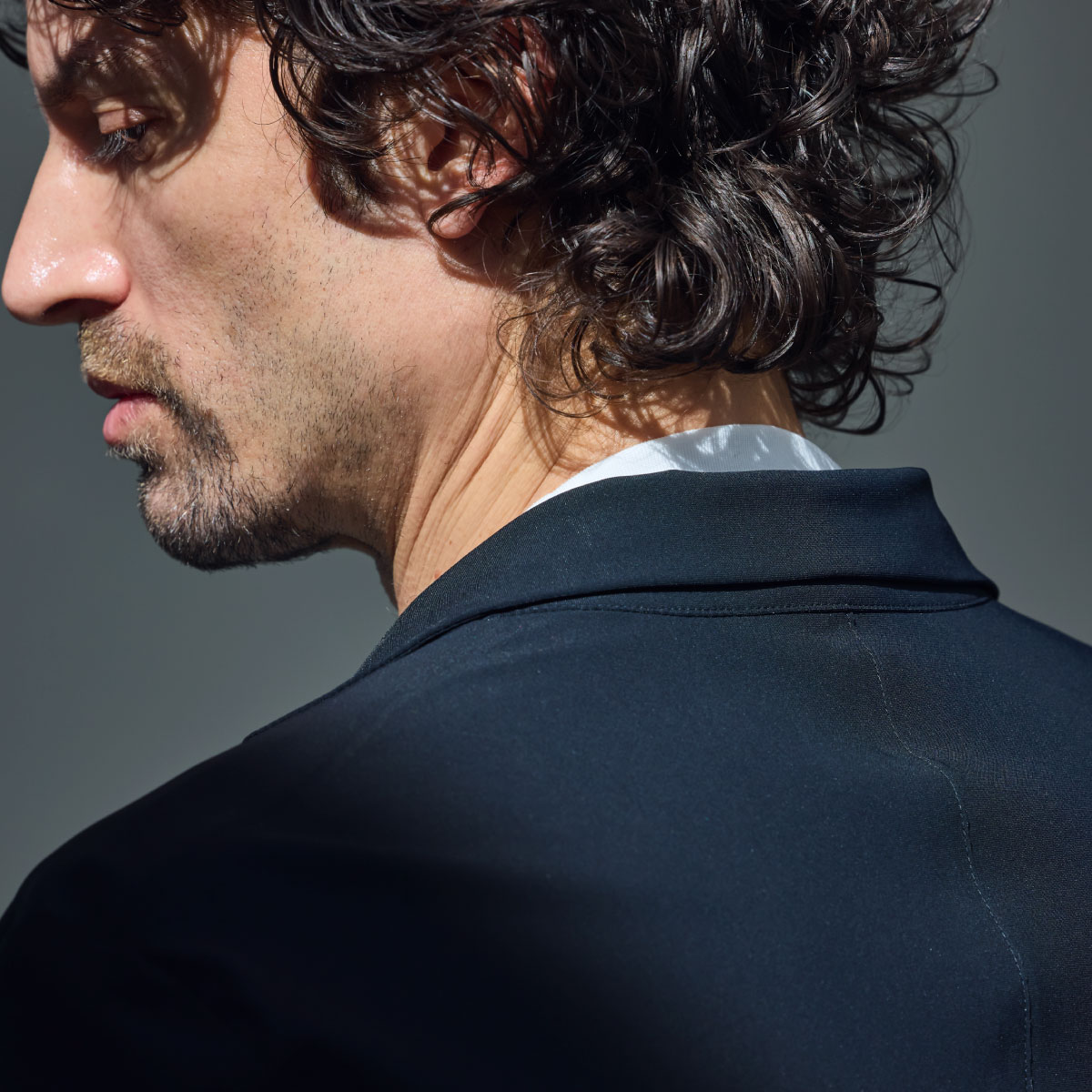 ホワイトのPACK T-SHIRT・ブラックのジャケットを着用した男性