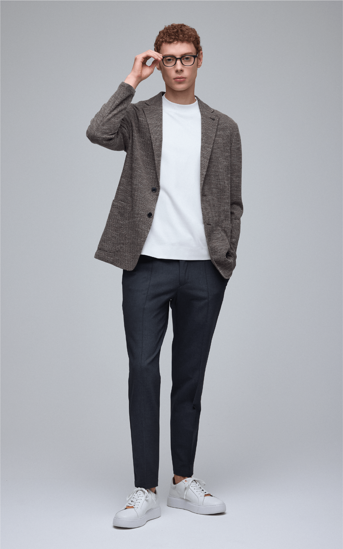 ブルゾン、ニット、パンツ、シューズを着用した男性