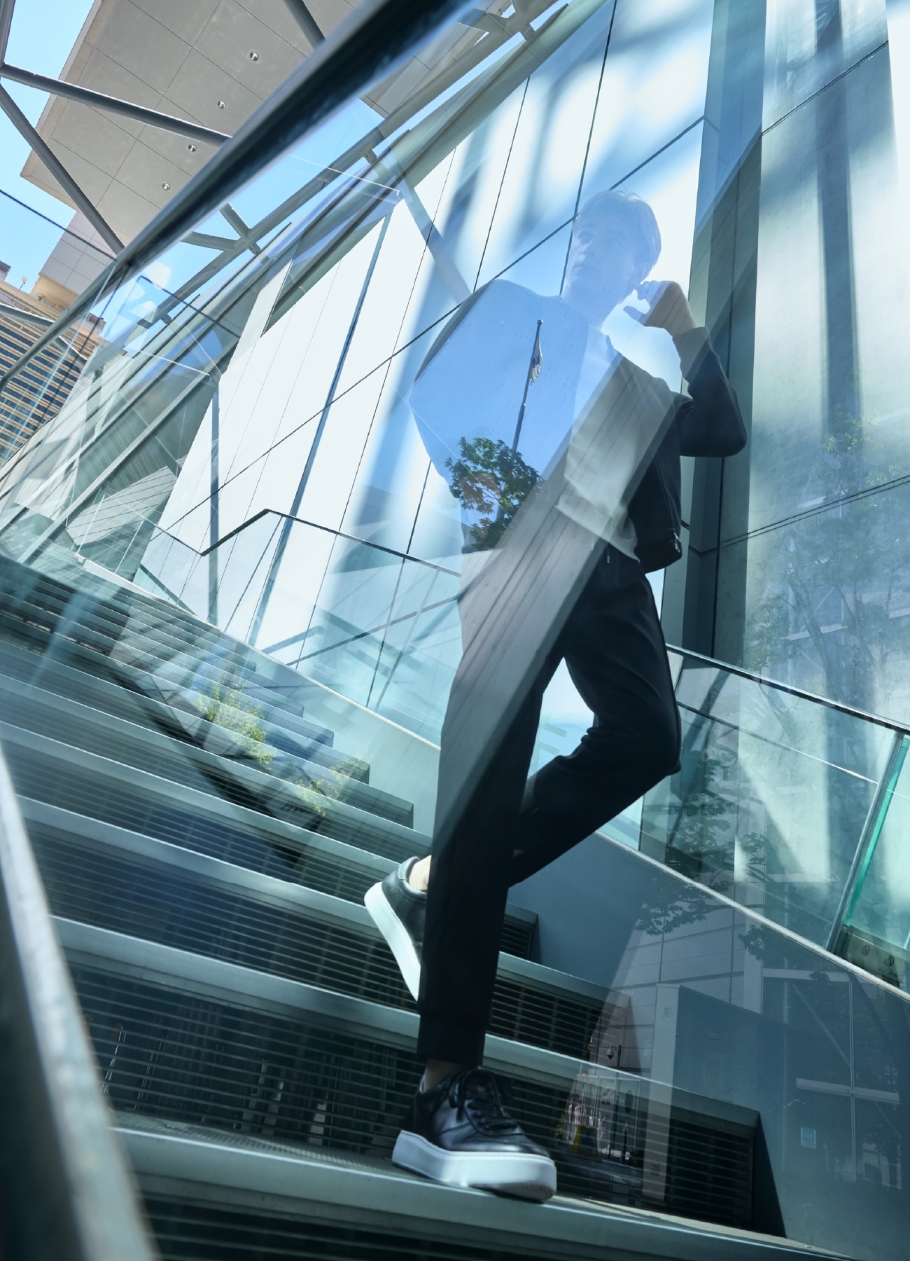 黒のスニーカー、黒のボトムス、黒のブルゾンにアイボリーのハイネックカットソーを合わせたコーディネート