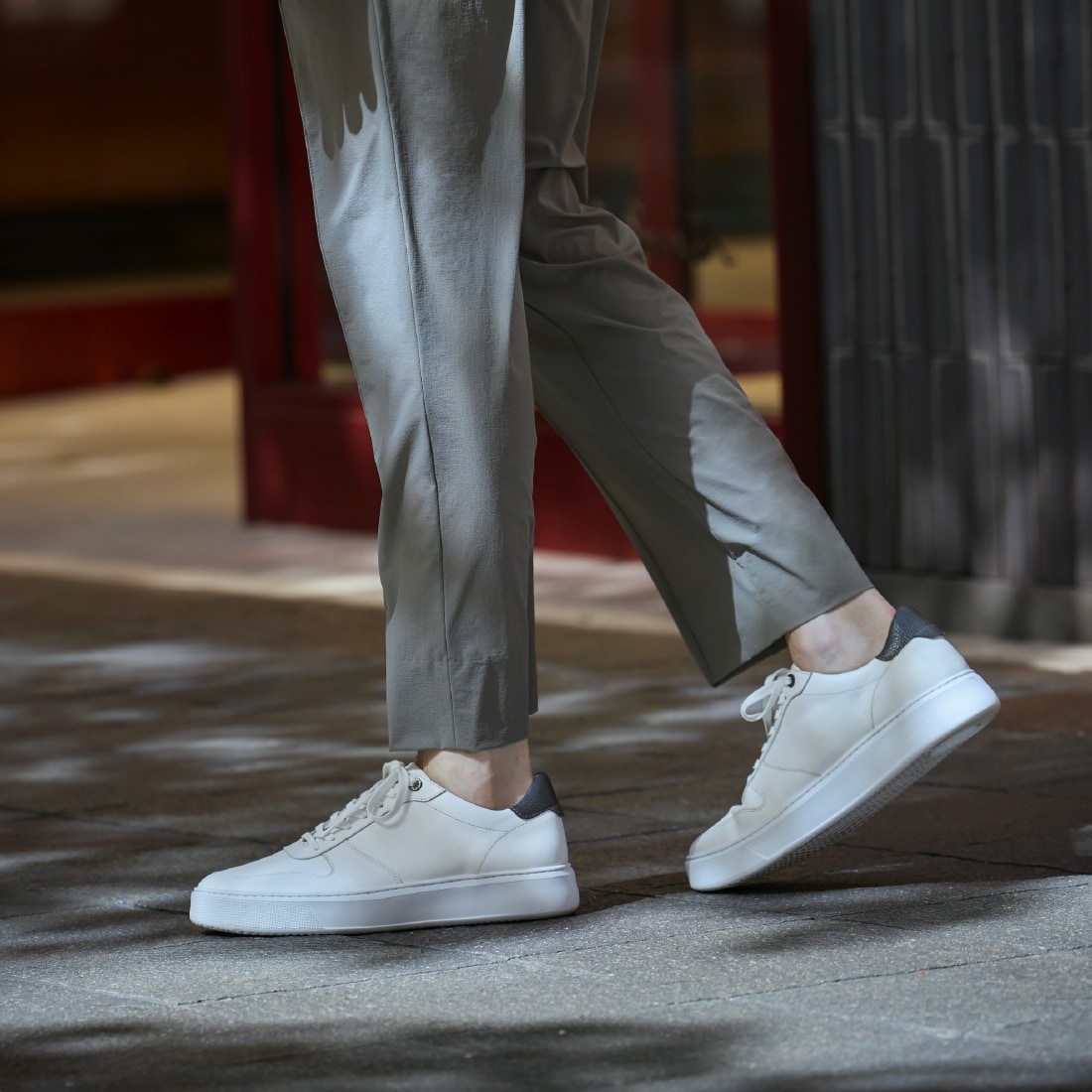 白のスニーカーとライトベージュのボトムスのアップ写真