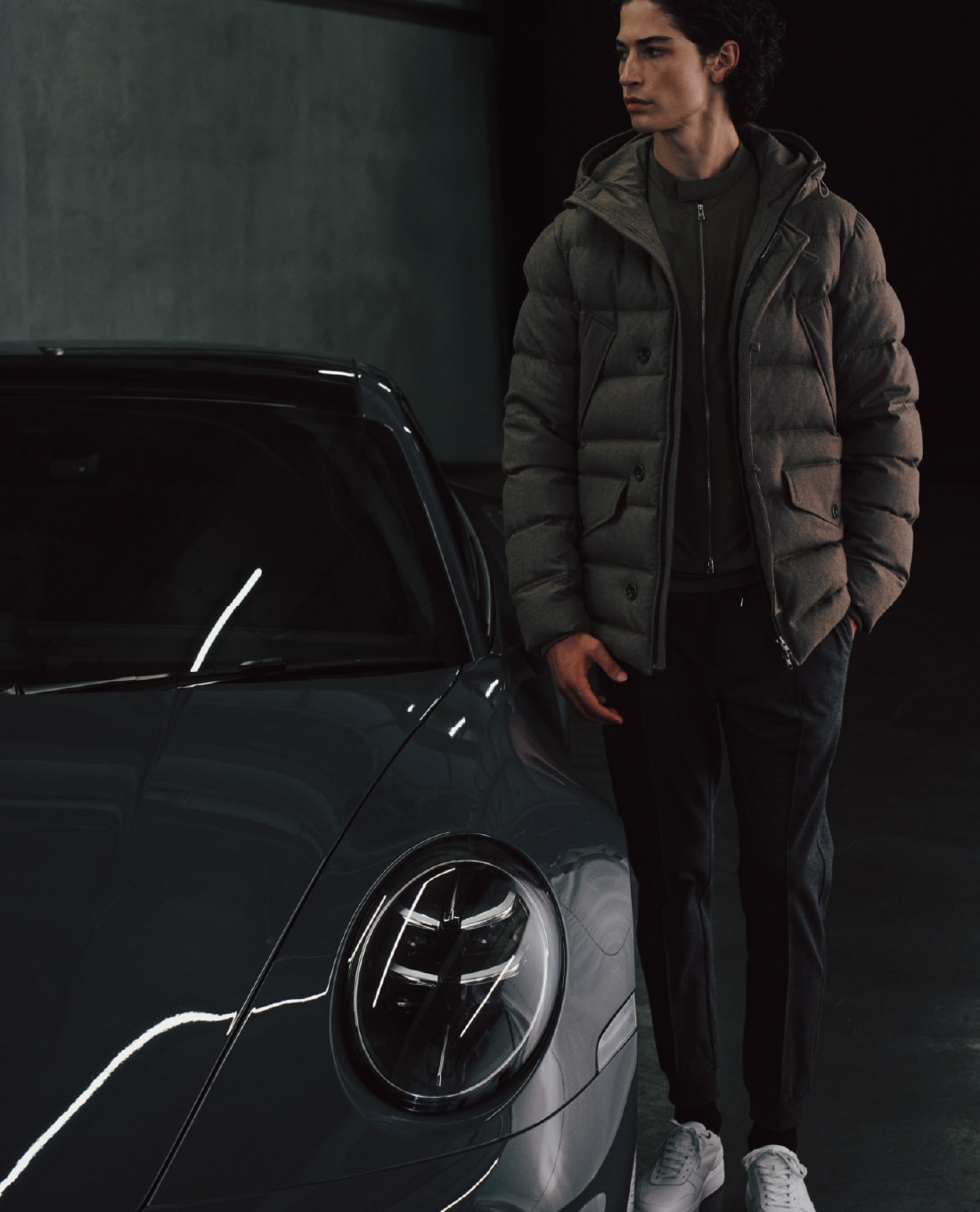 ライトベージュのウールダウンとコーラルグレイのリブパンツを着用した男性のビジュアル