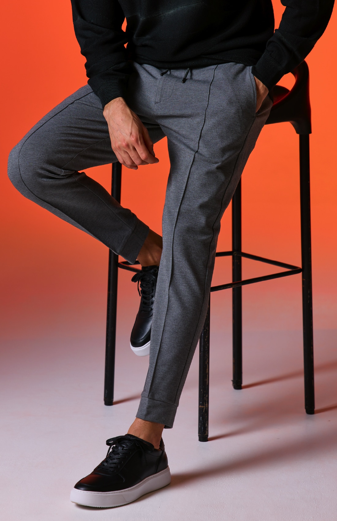 黒のＮＥＶＥ　ＣＡＭＯクルーネックニット、グレーのＬＵＸ．　ＷＡＲＭ　ＲＩＢ　ＰＡＮＴＳ、黒のＤＥＶＩＣＥ１　ＣＯＵＲＴ（シューズ）の着用例