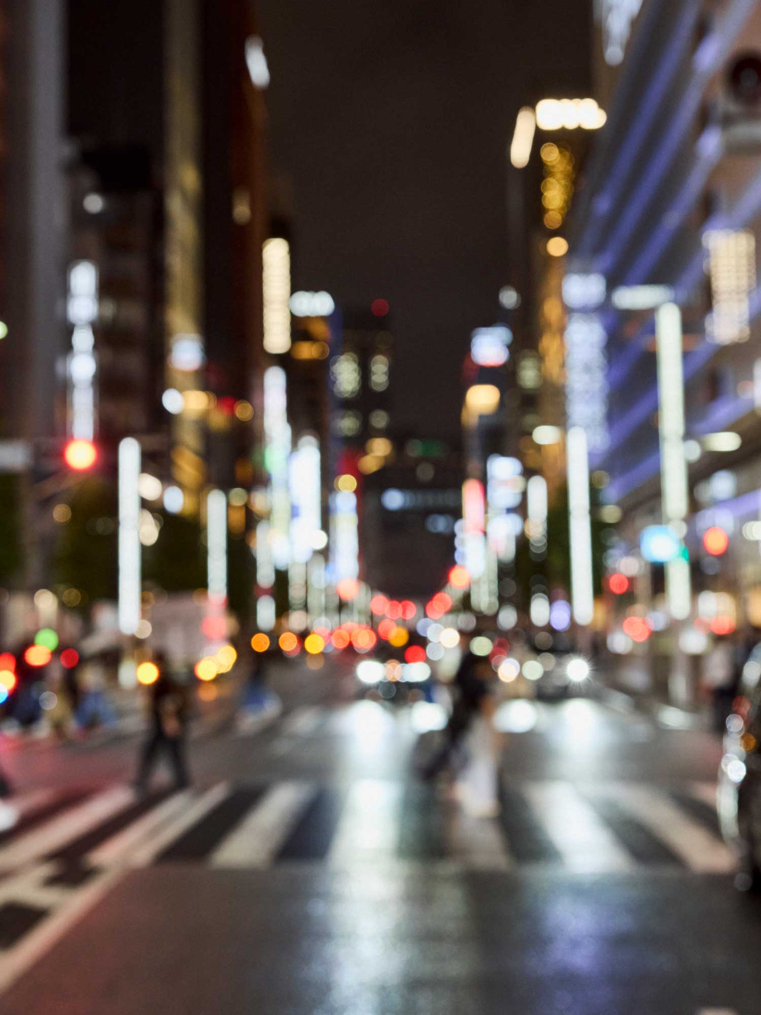 夜の交差点を渡るネイビーのセットアップ姿